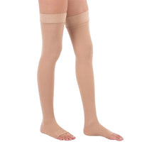 Bas de contention femme beige mi cuisse porté par une femme sur fond blanc